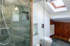 A modern bathroom with a glass shower enclosure, a toilet, and a skylight. - High Beckside -  Traditional Lakeland Cottage near Ullswater. Sleeps up to 7 guests (Penrith)