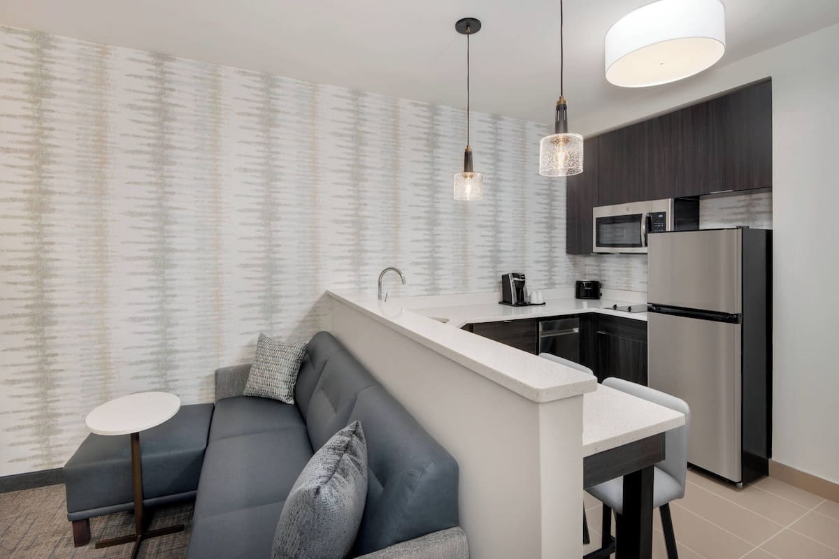A modern kitchen with a built-in island, stainless steel appliances, and pendant lighting.