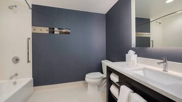 Une salle de bain moderne équipée d’une baignoire, de toilettes et d’un meuble-lavabo avec un miroir.