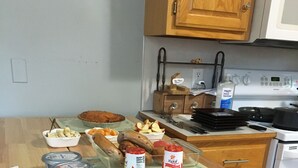 Eine Küche mit Holzausstattung, einem Herd und verschiedenen Lebensmitteln auf der Arbeitsfläche.