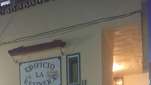 A building entrance with a sign reading "EDIFICIO LA RESINER" and a staircase leading inside. - Studio on the beachfront (Estepona)