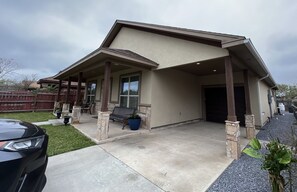 Ein modernes Haus mit überdachter Veranda, Garage und Auffahrt.