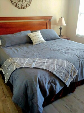 Restful retreat with a large bed, wooden headboard, and bedside table.