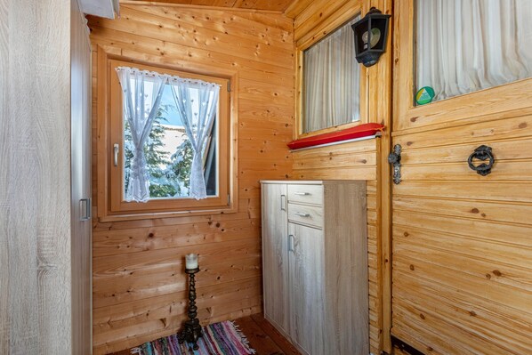 A wooden cabin interior with a window, a cabinet, and a door. - Cosy Holiday Home Moritz with Garden, Balcony, Terrace & Wi-Fi (Siegsdorf)