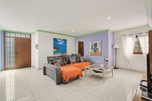 A living room with a sofa, a coffee table, and artwork on the walls. - Holiday Home “Casa las Cañas” with Mountain View, Sea View, Pool and Terrace (Icod de Los Vinos)