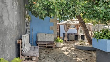 Un espace extérieur aménagé avec un canapé, une petite table et un kiosque.