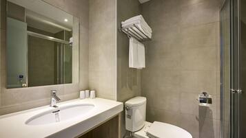 A modern bathroom with a sink, toilet, and glass shower enclosure.