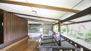 A room with a wooden floor, a glass table, and a painting on the wall. - OYO 1062 Baanrai Kongjaroen (Cha-am)