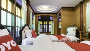 A hotel room with two beds, a television, a refrigerator, and large windows with curtains. - OYO 1062 Baanrai Kongjaroen (Cha-am)