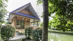 A building with a blue roof and a covered porch. - OYO 1062 Baanrai Kongjaroen (Cha-am)
