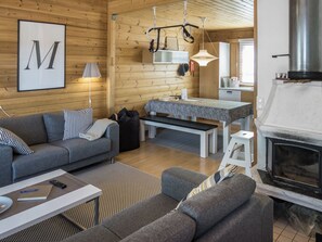 A cozy log cabin interior with a living area, dining table, and a fireplace. - Rukan komia chalet by Interhome (Kuusamo)