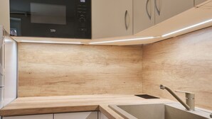 Eine moderne Küche mit integriertem Mikrowellenherd, Spüle und Holzschränken.
