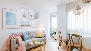 Una sala de estar moderna con un sofá gris, una mesita de centro y un comedor con mesa y sillas.