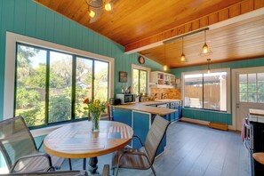 Enjoy cooking in this well-equipped kitchen with a central island, ample counter space, and a large window offering a view of the surrounding greenery.