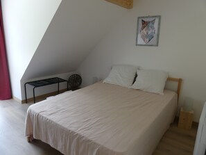Cozy loft-style room with a single bed and a decorative wall piece.