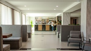 Un vestíbulo moderno con zonas de estar, un bar y una recepción.
