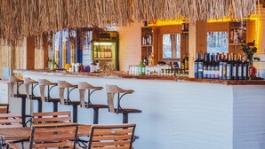 A bar area with wooden chairs and a thatched roof. - Kalkan Saray Suites - Adults Only (Kas)