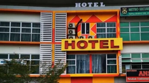 A hotel building with a prominent 'HOTEL' sign, a yellow car parked in front, and a visible entrance. - New Wave Cyberjaya Hotel (Cyberjaya)