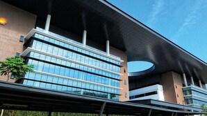 A modern building with a Shell logo, featuring a glass facade and a curved overhang. - New Wave Cyberjaya Hotel (Cyberjaya)