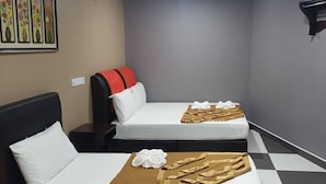 A hotel room with two beds, a checkered floor, and a small shelf with a decorative item. - New Wave Cyberjaya Hotel (Cyberjaya)