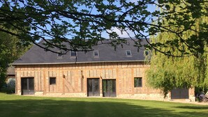 Ein großes Backsteinhaus mit symmetrischer Fassade, mehreren Türen und Fenstern.