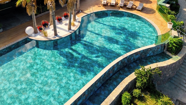 Un complexe hôtelier doté d’une grande piscine, d’un espace de détente et offrant une vue sur les montagnes.