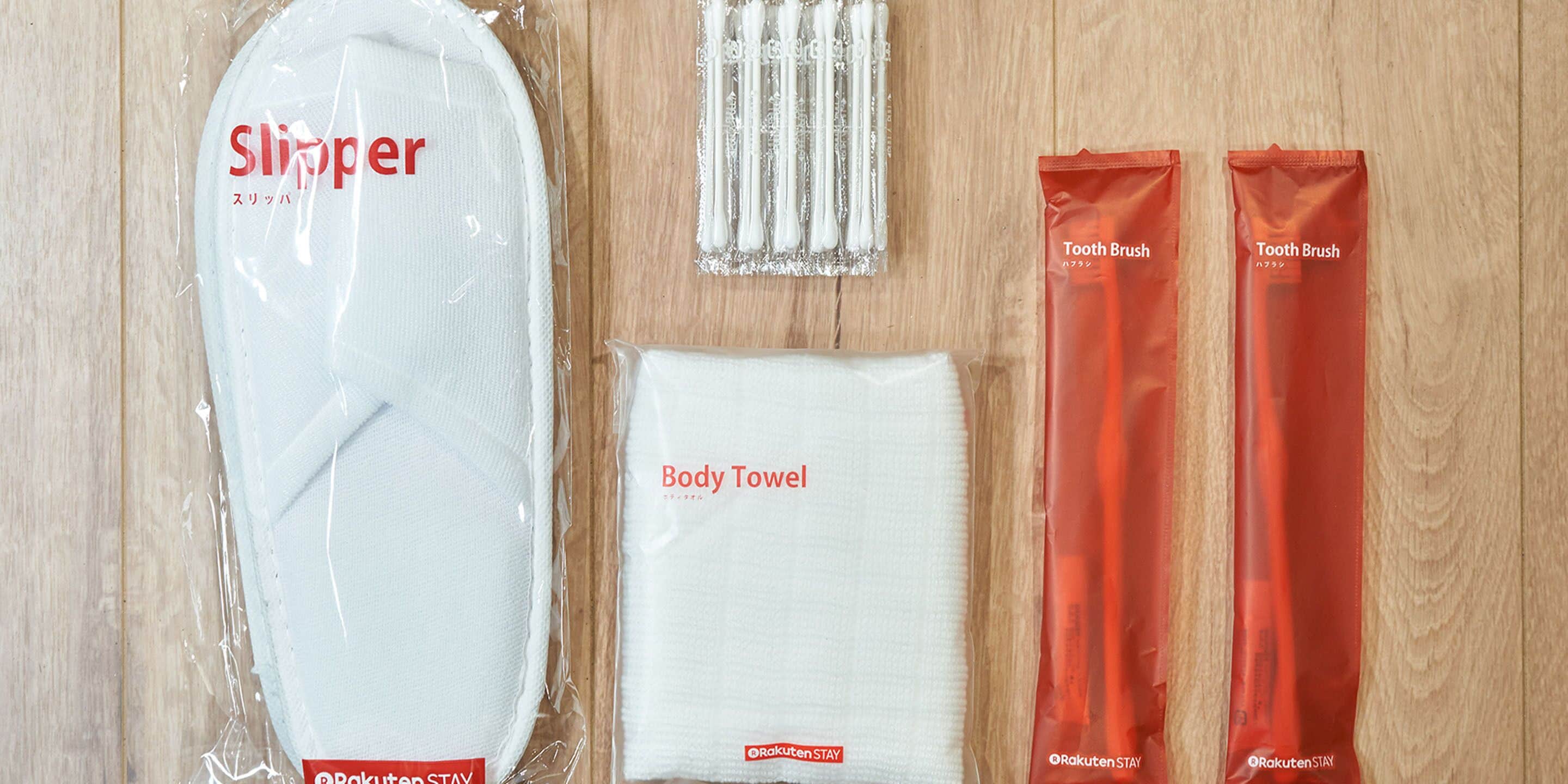 Un paquete con un pantufla, una toalla de baño y dos cepillos de dientes.