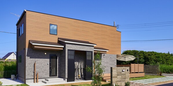 A modern two-story house with a wooden facade, a small balcony, and a garage.