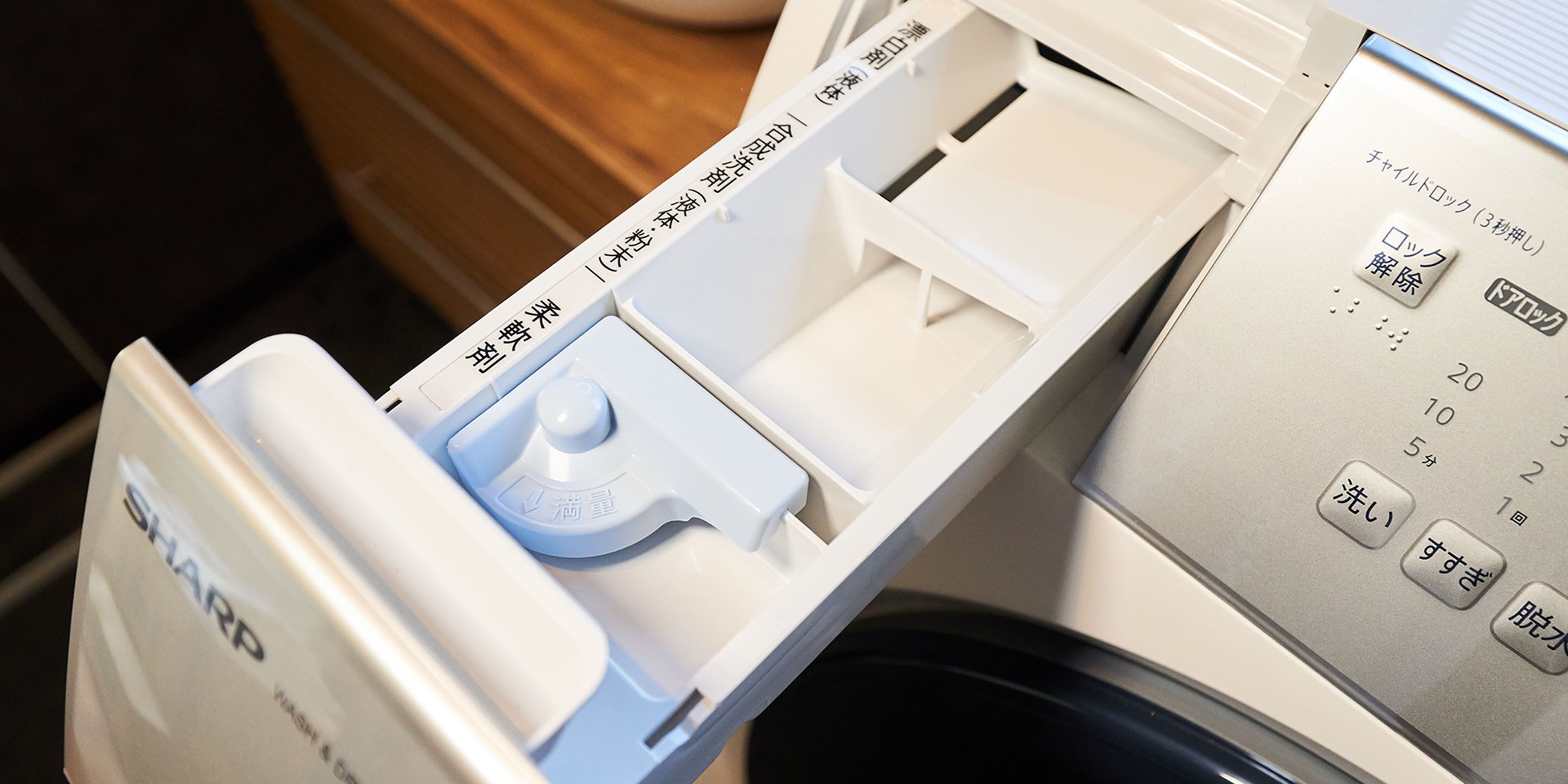 Electrodoméstico blanco y azul con texto en japonés, probablemente una lavadora o lavavajillas.