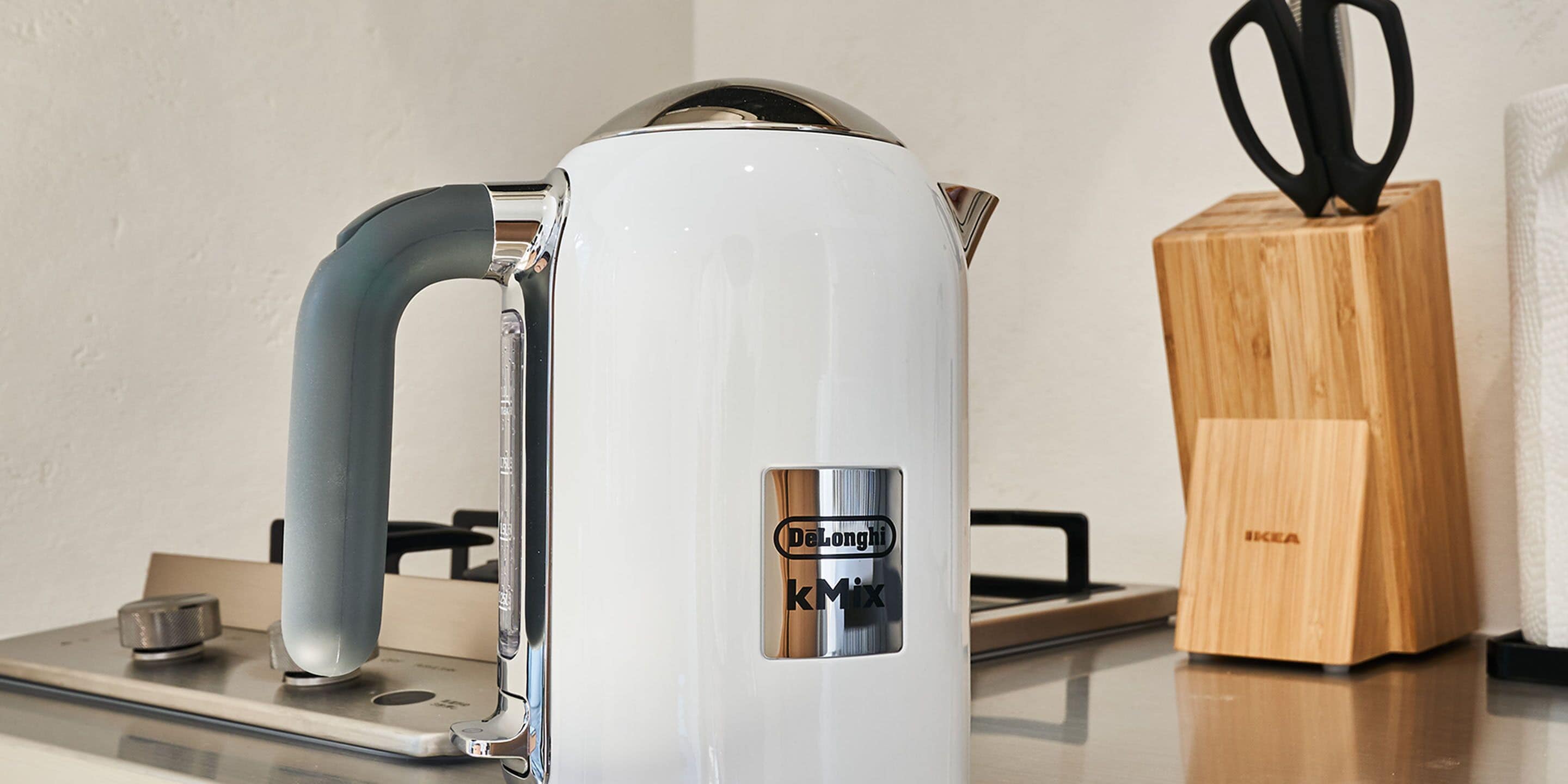 A white kettle with a handle and a control panel on a kitchen counter.