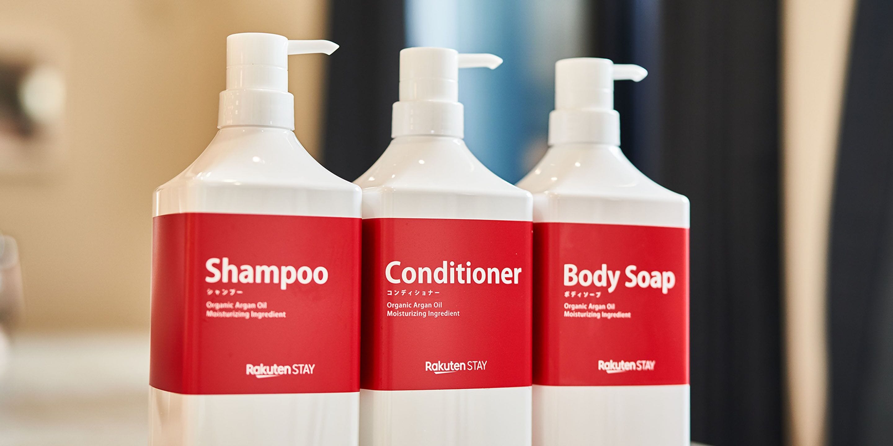 Three bottles of Rakuten Stay products: Shampoo, Conditioner, and Body Soap.