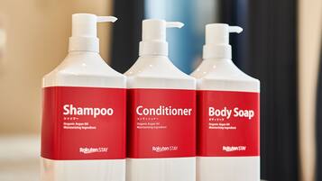 Three bottles of Rakuten Stay products: Shampoo, Conditioner, and Body Soap.