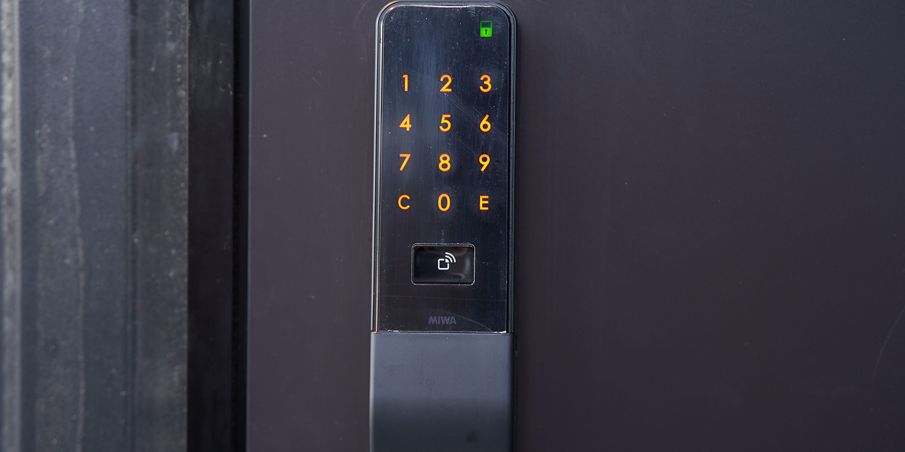 Une serrure à clavier numérique noire, fixée sur une porte.