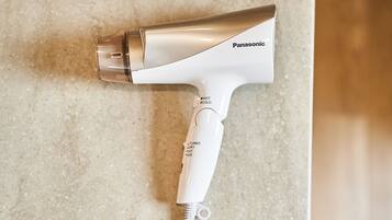 Ein Panasonic-Haartrockner mit weiß-silbernem Design auf einer strukturierten Oberfläche.