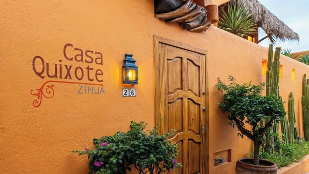 A building with a sign reading 'Casa Quixote' and a wooden door. There are potted plants and a lantern on the wall. - Rarely Available- Casa Quixote - Beachfront Estate (Zihuatanjeo)