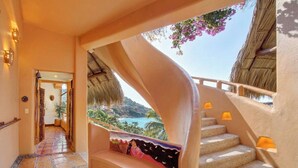 A curved staircase with a view of the sea, a tiled floor, and a wall with a mural. - Rarely Available- Casa Quixote - Beachfront Estate (Zihuatanjeo)