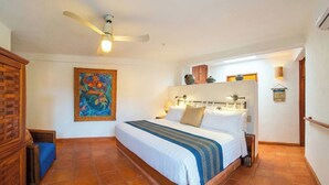 A bedroom with a bed, a ceiling fan, a painting, and a tiled floor. - Rarely Available- Casa Quixote - Beachfront Estate (Zihuatanjeo)