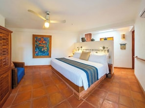 A bedroom with a bed, a ceiling fan, a painting, and a tiled floor. - Rarely Available- Casa Quixote - Beachfront Estate (Zihuatanjeo)