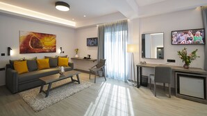 Uma sala de estar moderna com um sofá cinzento, uma mesa de centro, uma escrivaninha e um pequeno armário.