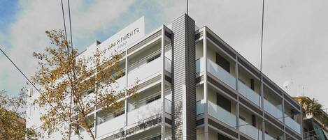 A multi-story building with a sign indicating it is an apartment complex.