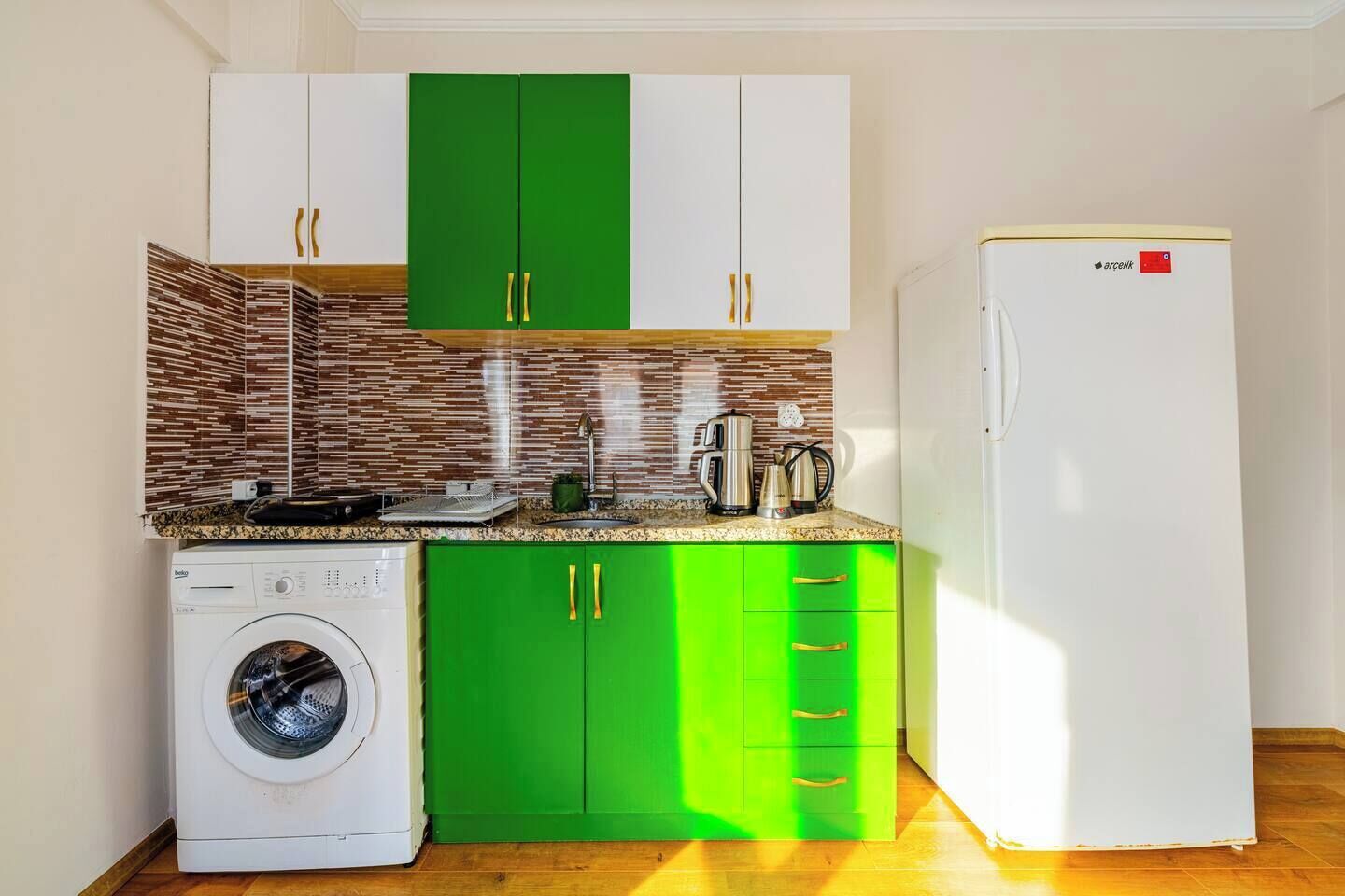 Kjøleskap, kokeplater, høy barnestol og steketakke