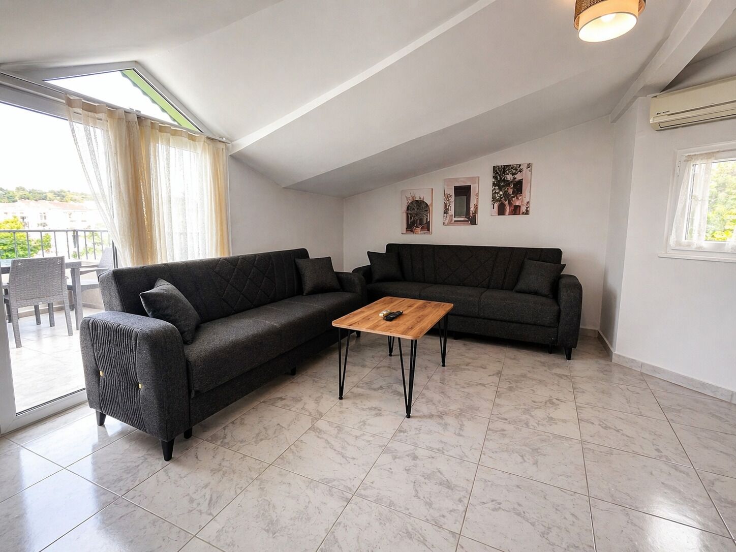 Una sala moderna con un sofá modular, una mesa de centro de madera y un comedor con sillas.
