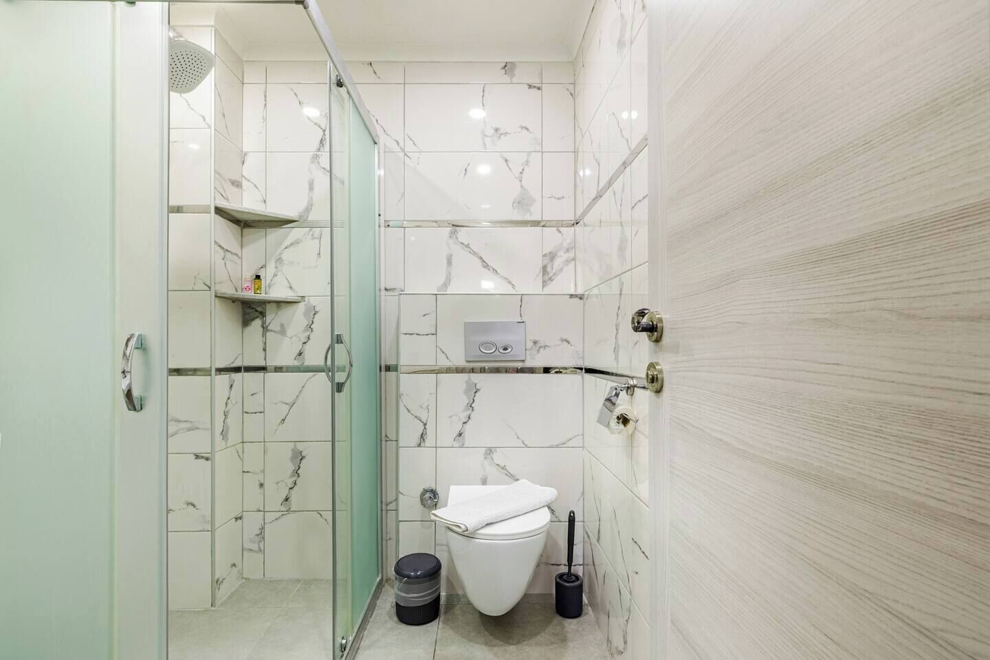 Un bagno con il WC, una doccia e un box doccia in vetro.