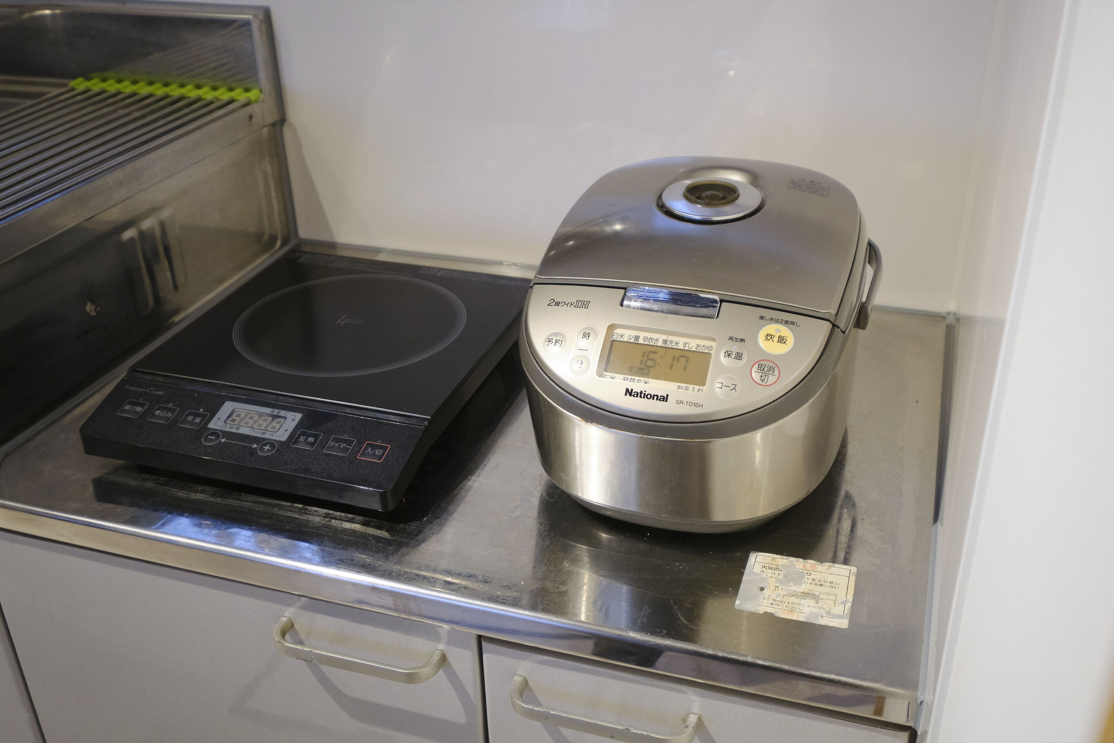 A kitchen with a rice cooker and an induction cooktop.