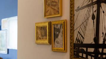 A wall with three framed artworks and a large black and white painting.