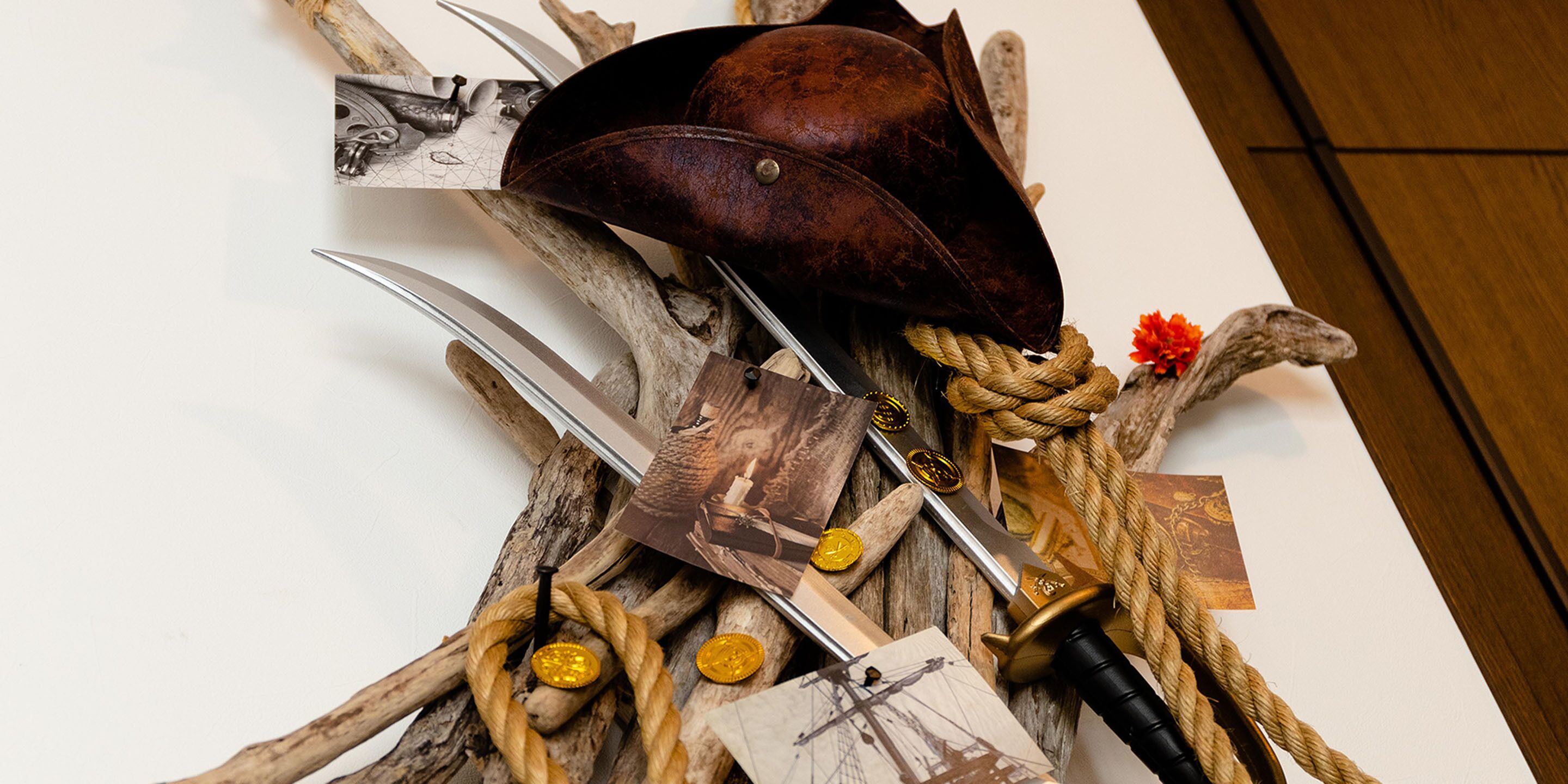 A collection of antique tools and a leather hat on a wooden surface.
