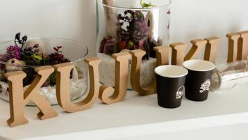 A decorative setup with letters spelling "KUJUR" and two black cups with skull designs.