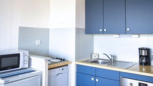 A compact kitchen with a microwave, dishwasher, sink, and cabinets.