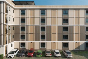 A multi-story building with a parking area in front.
