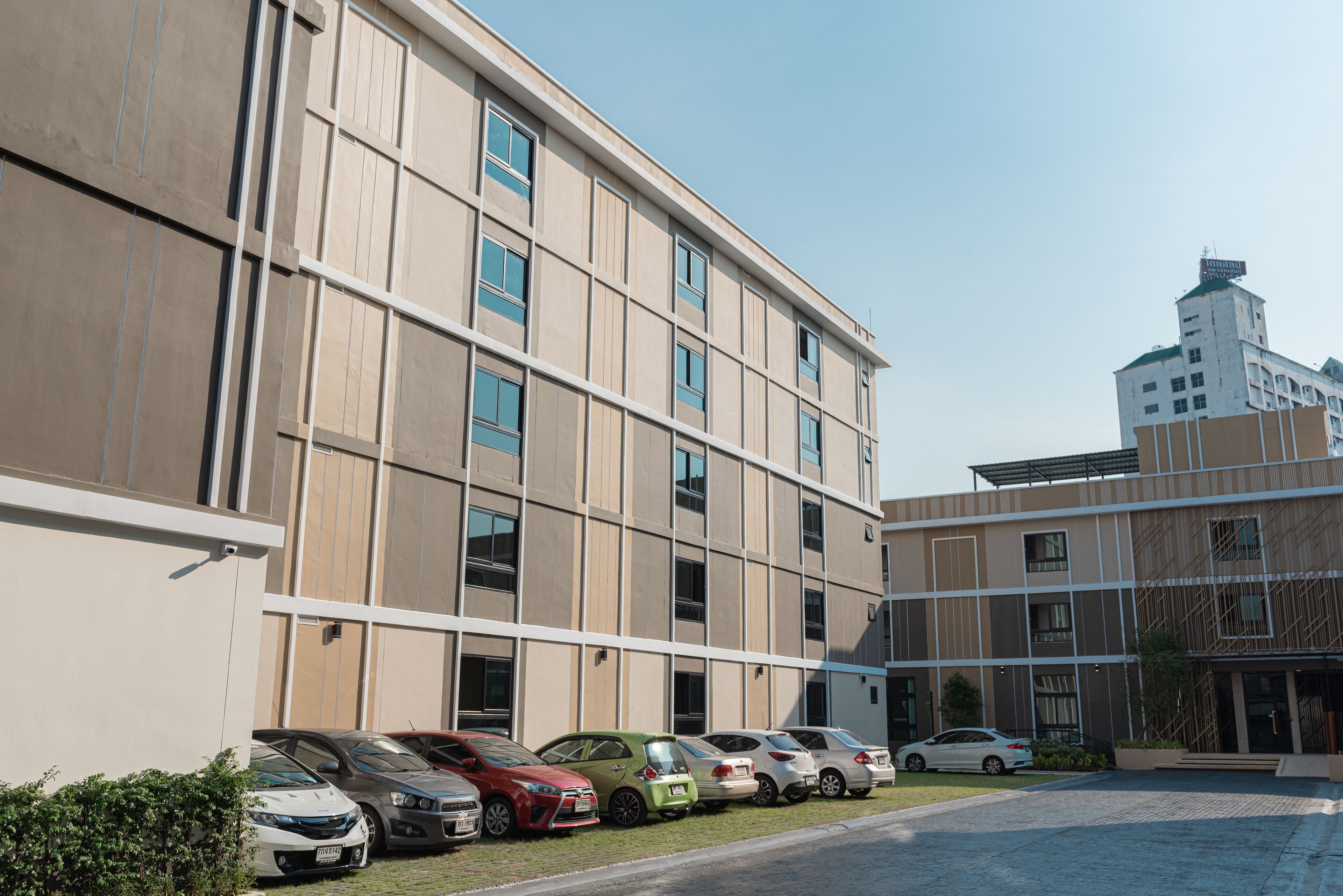 A modern building with a row of parked cars in front.